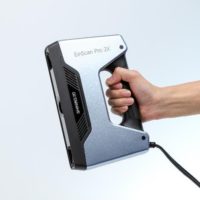 EinScan Pro 2X handheld 3D scanner with user holding it in his right hand.